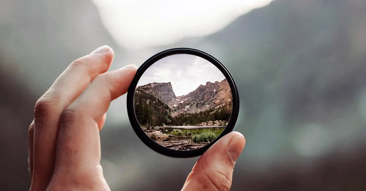 A hand holds a magnifying glass