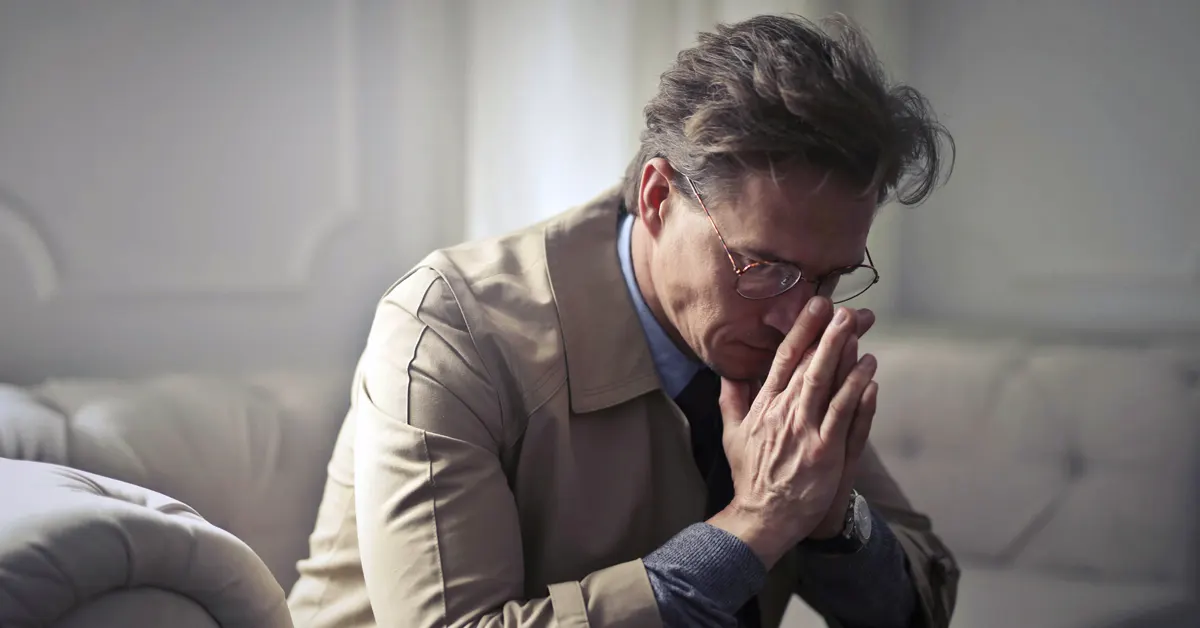 A forty-year-old man in a position of anxious reflection.