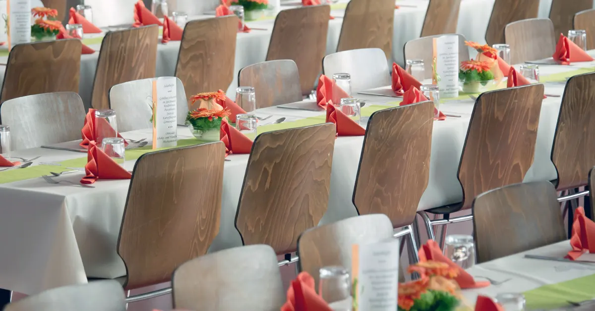 Long tables set up to accommodate a reception event.