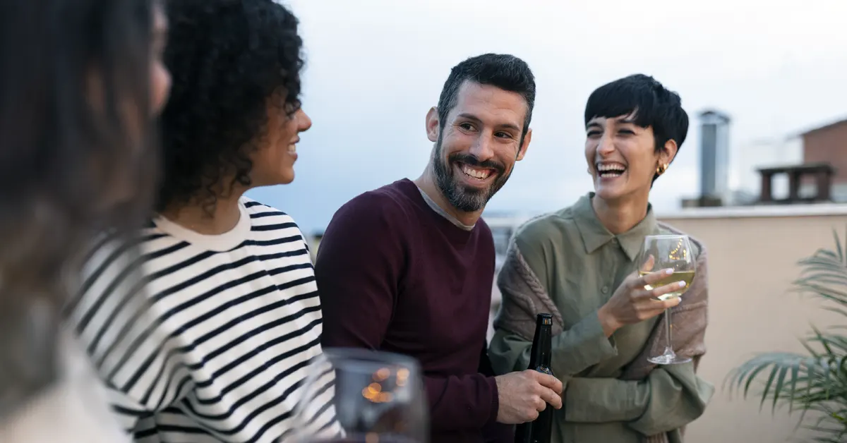 Four millennials share a joyful conversation, enjoying sparkling wine.