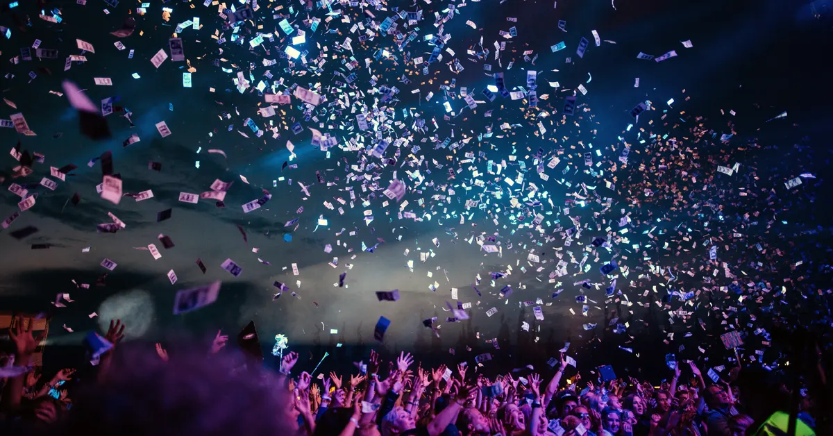 Outdoor show at night with confetti falling.
