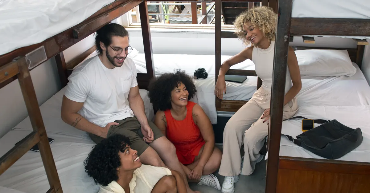 A family sits on a hotel room beds.
