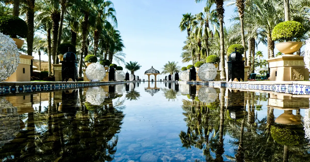 A swimming pool located in the heart of a green hotel.
